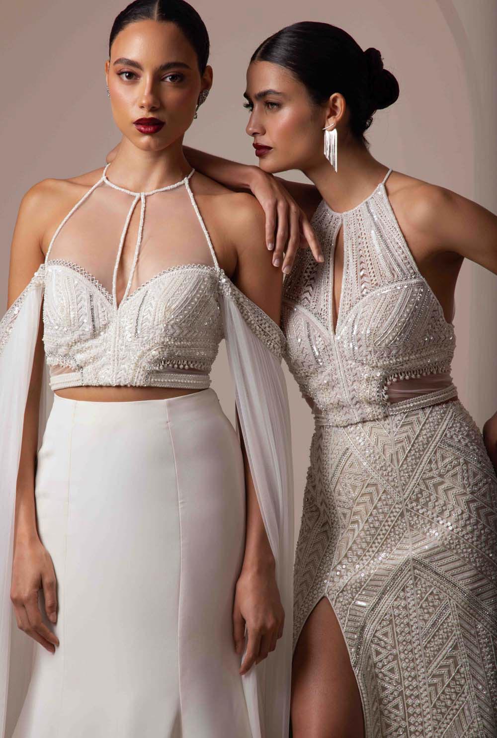 Two brides wearing contemporary ivory bridal outfits with geometric beading and modern silhouettes.