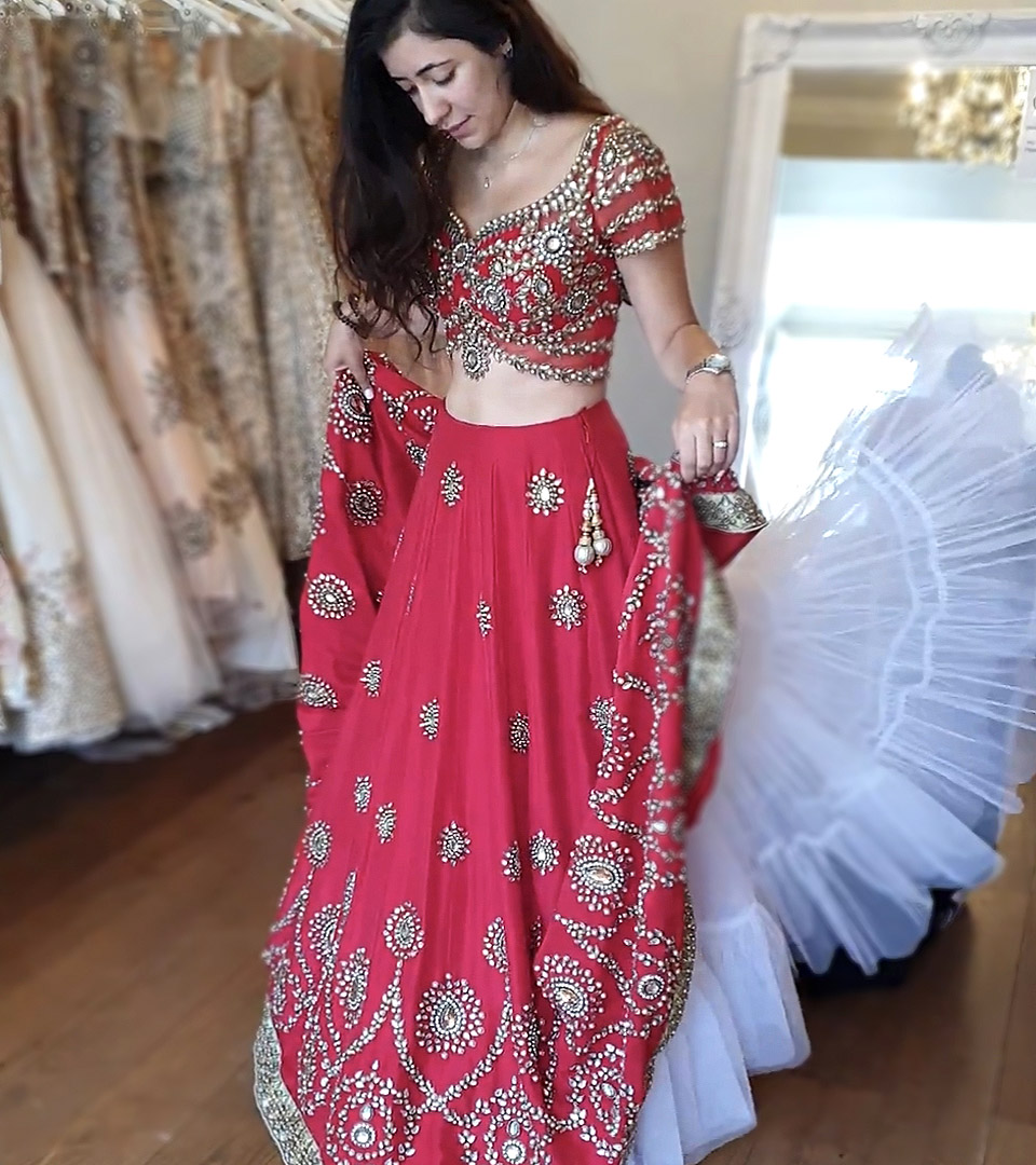 Bride trying her bespoke red Indian wedding lehenga at My Trousseau's showroom in London