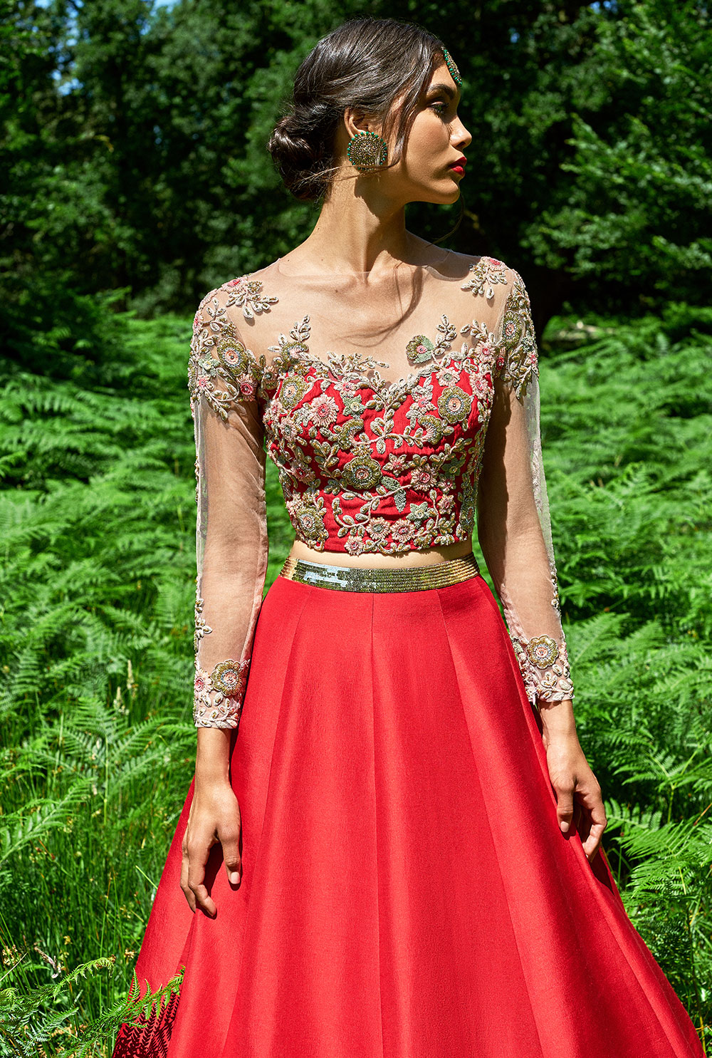 Bride wearing a red bridal lehenga with embroidery and embellishments